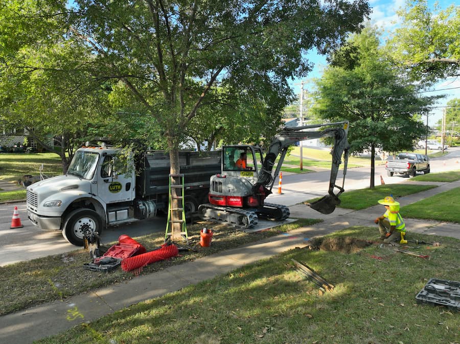Fred Luth truck and service equipment with employee in ground working on lead pipe replacement